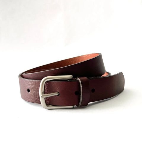 The Rogue Industries Chamberlain Leather Belt, 1.25 wide in dark brown handcrafted leather with a silver buckle, is shown coiled on a white background; proudly made in the USA.