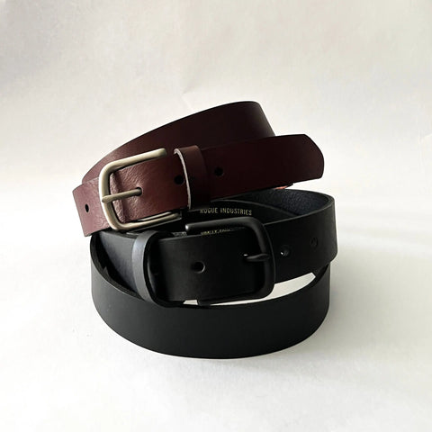 Two Chamberlain Leather Belts by Rogue Industries, one dark brown with a silver buckle and one black with a black buckle, are coiled together on a plain white background. Each is 1.25 wide and handcrafted in the USA.
