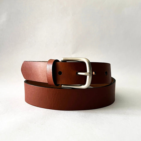 The Rogue Industries Chamberlain Leather Belt, 1.25 wide with a silver buckle, is handcrafted in the USA and displayed coiled on a plain white background.