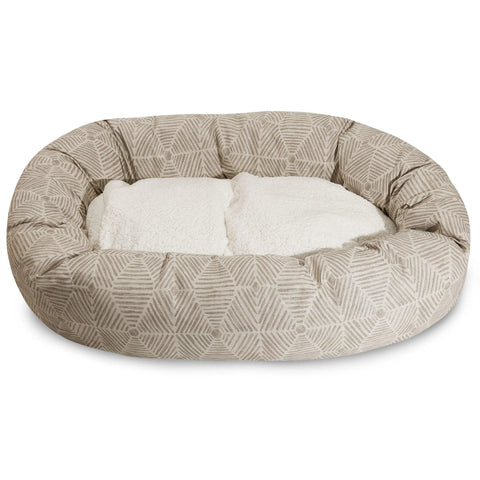 The Majestic Pet Charlie Sherpa Bagel Dog Bed features a beige geometric cotton twill exterior and a soft white fleece-like center. Its plush, water-resistant design offers comfort for small to medium-sized pets.