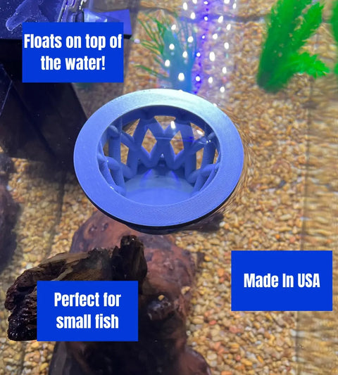 The Chatelet Aquarium Fish Feeding Cage by Chatelet Manufacturing floats on aquarium water above rocks and plants, keeping larger fish out. Blue boxes read: Floats at Surface!, Perfect for Small Fish, Made in USA.