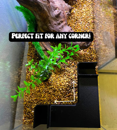 The Chatelet Aquarium Underground XL Corner Tunnel by Chatelet Manufacturing fits perfectly in any corner, creating unique aquarium decor next to plants and driftwood. Features a hideout and viewing tunnel for fish and shrimp. Text above: PERFECT FIT FOR ANY CORNER!.