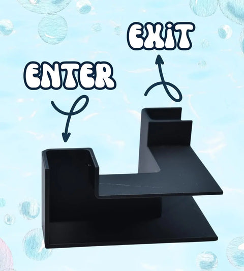 The Chatelet Aquarium Underground XL Corner Tunnel by Chatelet Manufacturing is a black, Z-shaped plastic fish and shrimp hideout labeled ENTER and EXIT in blue-and-white letters with arrows, set against a light blue, bubbly background. Made in USA.