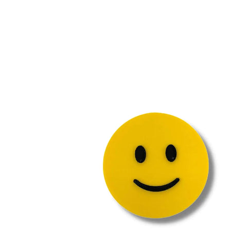 The Emoji Smiley Face decorative ideogram by Chatelet Manufacturing, featuring a black and yellow design, is shown as a 3D printed magnet in the lower right corner of a plain white background. Made in the USA.