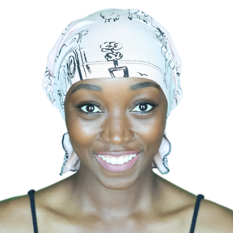 A smiling woman, facing forward against a plain background, wears the Chemo Beanies® Scarves - Chemo Beanies® - Stephanie slip-on beanie with a black top.