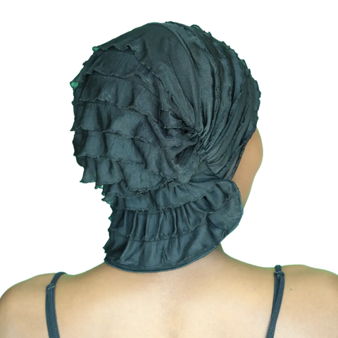 A person seen from behind wears a black Chemo Beanies® Scarves - Angelle chemo head cover with a textured, ruffled design, paired with a black spaghetti strap top.
