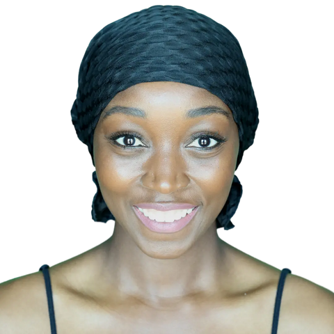 A woman with dark skin smiles warmly at the camera, modeling the Chemo Beanies® Emma scarf. The black textured headscarf from Chemo Beanies® offers stylish, comfortable cancer headwear, highlighting confidence and elegance against a plain background.