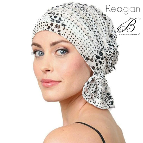 A woman with light eyes wears the Reagan Chemo Beanies® patterned black and white scarf, looking over her shoulder. The Chemo Beanies® logo appears in the top right corner.