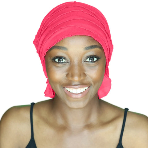 A woman wearing the Carol Chemo Beanie® by Chemo Beanies®, paired with a black spaghetti strap top, smiles warmly at the camera against a white background.