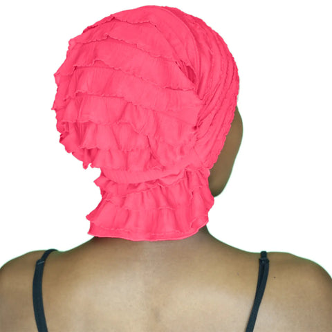 A person with dark skin is seen from behind, wearing the Chemo Beanies® Carol bright pink ruffled beanie and a black spaghetti strap top, set against a white background.