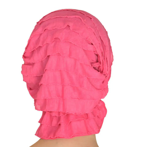 A person wearing the Chemo Beanies® Carol scarf, a bright pink, layered ruffle headwrap from Chemo Beanies®, photographed from behind against a white background.