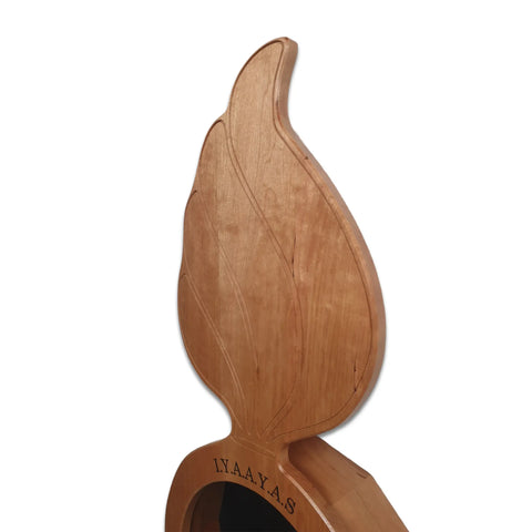The Cherry Ammo Pisspot Shadow Box by Legacies of America Woodworking Company is a USA-made cherry hardwood sculpture featuring a large flame-shaped design, I.Y.A.A.Y.A.S engraving near the top, and a plain white background.