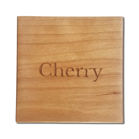 The Cherry Ammo Pisspot Shadow Box by Legacies of America Woodworking Company is a square piece crafted from cherry hardwood, engraved with Cherry at the center, showing a light reddish-brown hue and natural wood grain. Made in USA.