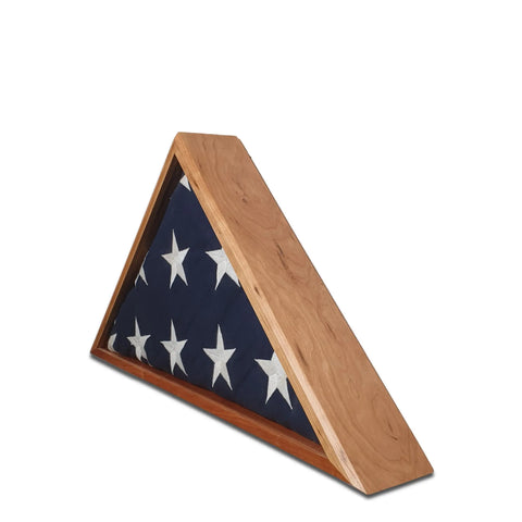 A folded 5 x 9.5 American flag with white stars rests in the Cherry Burial Flag Display Case by Legacies of America Woodworking Company, handcrafted in the USA and shown against a white background.