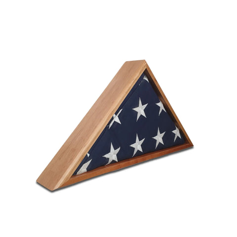 A folded American flag with white stars on blue rests in the Legacies of America Woodworking Company Cherry Burial Flag Display Case (5 x 9.5) against a white background.