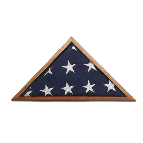 A folded 5 x 9.5 U.S. flag with white stars on blue rests in the Cherry Burial Flag Display Case by Legacies of America Woodworking Company, handcrafted in America and set against a white backdrop.