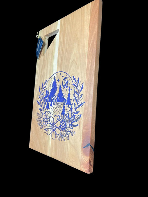 The Purple Epoxy Cherry Inlay Serving Tray by B. James Design & Woodwork features a unique purple epoxy design on cherry wood. Photographed at an angle on a black background, this tray combines decorative artistry with practical function.