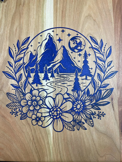 This B. James Design & Woodwork Purple Epoxy Cherry Inlay Serving Tray features a detailed blue mountain, tree, river, and moon scene engraved on wood, framed by leafy branches and large flowers for a decorative touch.