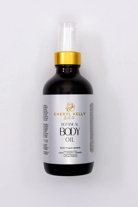 A 4 fl oz dark amber bottle with gold and white pump, labeled Cheryl Kelly & Co. Botanical Body Oil, sits on a white background—an elegant, organic oil designed to nourish your skin.