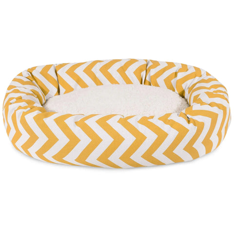 The Majestic Pet Chevron Sherpa Bagel Dog Bed features yellow and white chevron-patterned outdoor-treated polyester sides and a soft, plush white center for gentle spine support.