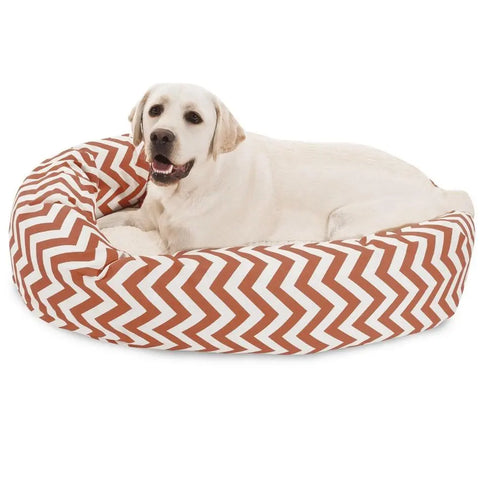 A light-colored Labrador retriever is lying contentedly on the Majestic Pet Chevron Sherpa Bagel Dog Bed, which features a brown and white chevron pattern in water-resistant, outdoor treated polyester for lasting durability.