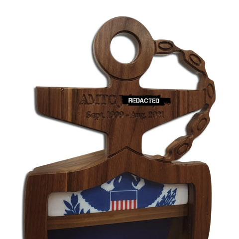 The Coast Guard Chief Petty Officer (CPO) Anchor Shadow Box by Legacies of America Woodworking Company is a wooden anchor-shaped plaque with chain, crafted from real hardwoods by veterans, engraved with AMTC [redacted] Sept. 1999 – Aug. 2021, partly covering a blue and white emblem featuring a red and white shield.