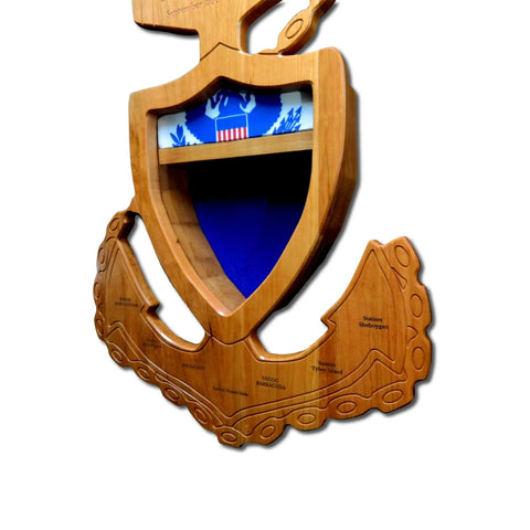 The Coast Guard Senior Chief Petty Officer (SCPO) Anchor Shadow Box by Legacies of America Woodworking Company is a USA-made wooden display shaped like an anchor and shield, with engraved names, a blue-and-white U.S. flag emblem, and an empty shelf below.