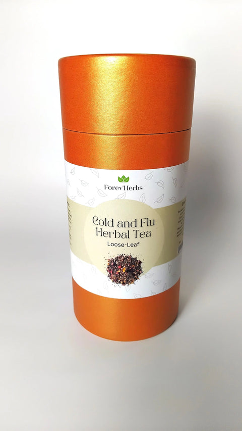 A cylindrical orange canister labeled Forev'Herbs Cold and Flu Herbal Tea features a small image of loose tea leaves on the front. This immune-boosting herbal tea is ideal for cold relief. Plain white background.