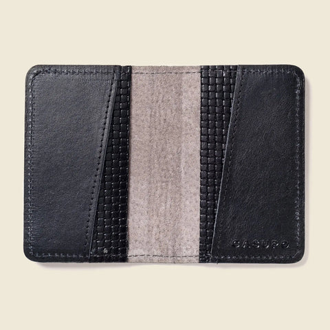 The CASUPO Compact Bifold With RFID Protection - Black Limited Edition features textured diagonal accents, a smooth central panel, and embossed branding. Shown open and empty on a beige background.