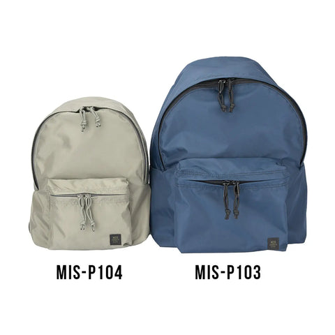 Two backpacks side by side: a smaller black nylon backpack labeled MIS Daypack S and a larger blue made-in-USA backpack, both with front zip pockets and drawstrings.