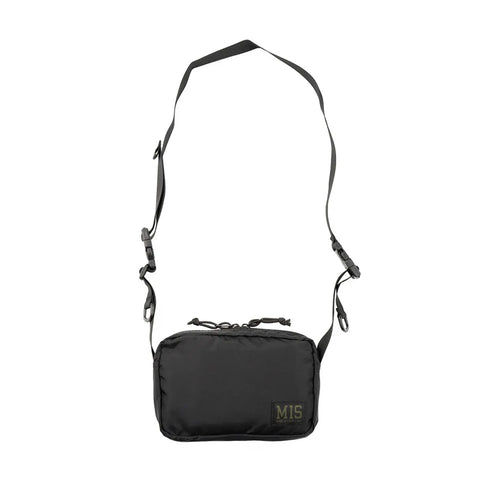 The MIS AW Shoulder Bag S - Black is a compact packcloth nylon crossbody with water-resistant finish, adjustable shoulder strap, zippered main compartment, and an MIS logo patch on the lower right corner.