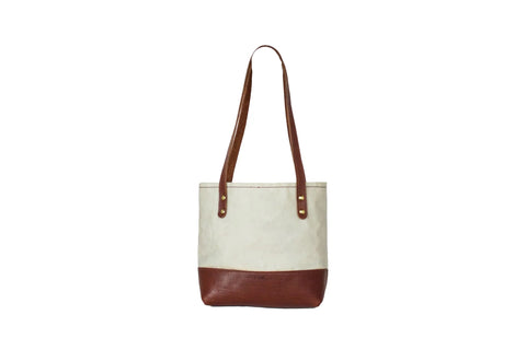 The Urban Southern Mini Canvas Tote features a cream-colored body with brown leather straps and a matching leather bottom, displayed on a white background.
