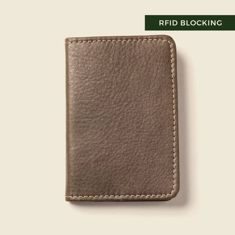 A grey sustainable leather wallet from CASUPO, the Compact Bifold With RFID Protection, is shown closed on a light background. A dark green label in the top right corner highlights its RFID blocking feature in white text.