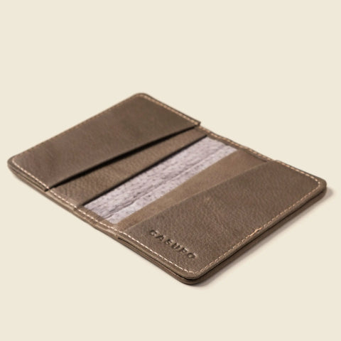 CASUPO's Compact Bifold With RFID Protection in grey features multiple card slots, including one with a partially visible card, displayed open on a light beige background.