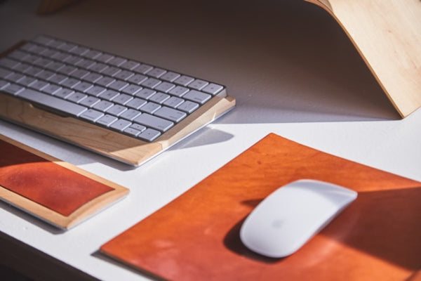Keyboard and mouse on a desk with a wooden surface