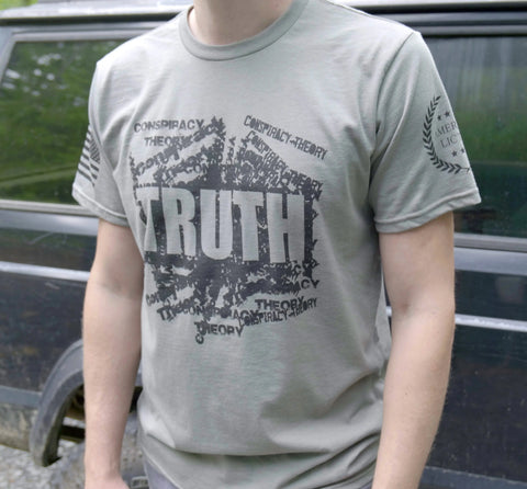 Someone wears the American Lictor Conspiracy-Truth T-shirt—gray with bold TRUTH and repeated smaller CONSPIRACY and THEORY—evoking tin foil hat vibes. A black car appears in the background.