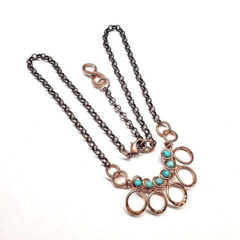 The As Seen on Ashley Liao Copper Turquoise Wire Wrapped Necklace by Alexa Martha Designs features five turquoise jasper gemstones in a fan-shaped copper pendant on a dark metal chain, shown on a white background.
