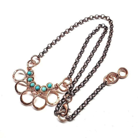 The As Seen on Ashley Liao Copper Turquoise Wire Wrapped Necklace by Alexa Martha Designs features five turquoise beads in circular copper frames with teardrop links, presented on a white background.