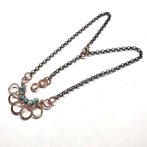 The Alexa Martha Designs As Seen on Ashley Liao Copper Turquoise Wire Wrapped Necklace features interlocking gold loops and five turquoise beads on a dark chain for an abstract, artistic look.