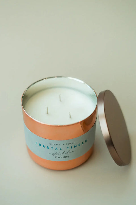 The Shanti + Tula Copper Vessel 3-Wick Soy Candle features a pale blue Coastal Timber label and matching lid, offering clean-burning luxury fragrance and stylish, gift-ready decor—all made in the USA.