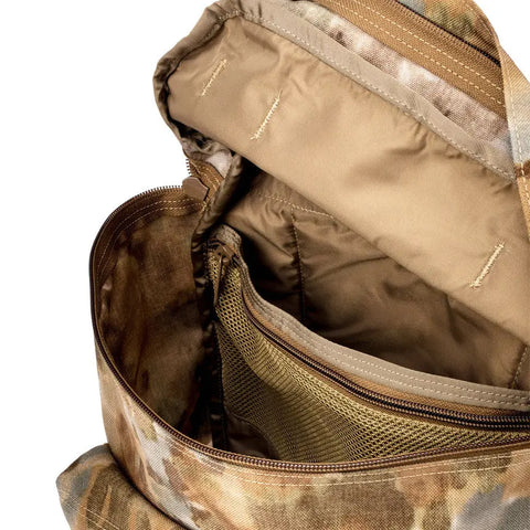 Close-up of the MIS Backpack - Covert Desert interior, featuring tan lining, a zippered mesh pocket, multiple organizational compartments, and a padded laptop sleeve.