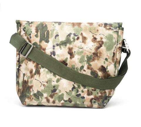 The MIS Messenger Bag - Covert Woodland is a rectangular Cordura Nylon bag featuring a green and brown camouflage pattern with an adjustable olive green strap, made in the USA, shown on a white background.