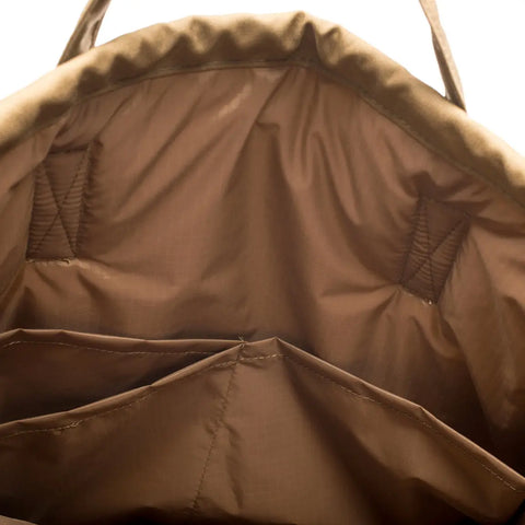 Close-up of the interior of the MIS UK Helmet Bag in Coyote Brown, made in USA from 500D Cordura Nylon, showing multiple stitched pockets, compartments, visible seams, and top handles.
