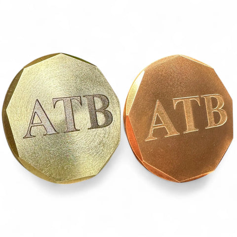 Fairway Reserve’s Personalized Ball Markers (Set of 2) feature metallic gold and copper coins engraved with ATB, crafted from brass and copper—stylish golf ball markers that add a personal touch on the course.