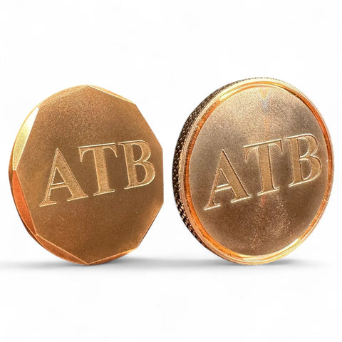 The image shows a set of two Personalized Ball Markers by Fairway Reserve, each engraved with ATB, displayed in gold color—one upright and one tilted—against a white background.