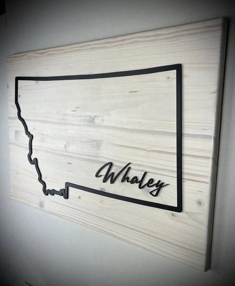 The Large Rectangle Personalized MT Sign by B. James Design & Woodwork features a Montana outline and Whaley script on a light wood background—custom colors available to match your style and create unique decor for your space.
