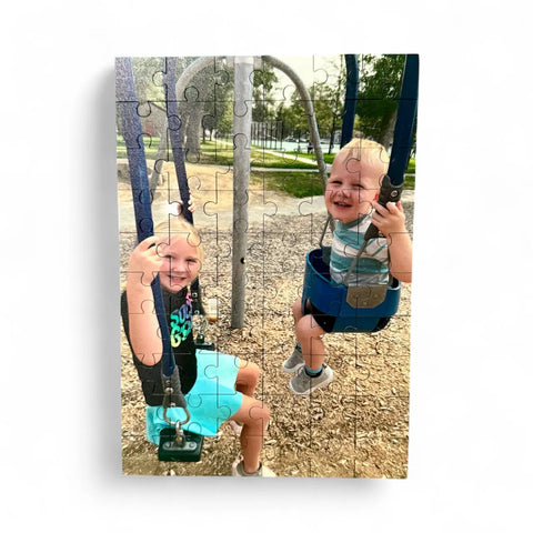 Capture the joy of two children on swings at a wood chip playground with a Custom Printed Puzzle by B. James Design & Woodwork, available in 60 or 30 pieces. Perfect for preserving special moments as a fun keepsake activity.