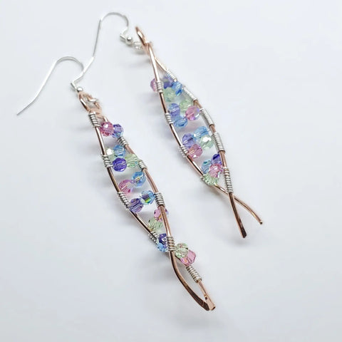 The DNA Strand Double Helix Long Crystal Earrings by Alexa Martha Designs feature twisted copper wire frames and pastel crystal beads in purple, blue, green, and pink, elegantly displayed on a white background.
