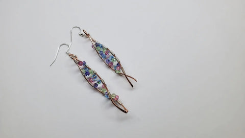 DNA Strand Double Helix Long Crystal Earrings by Alexa Martha Designs feature twisted copper wire frames, colorful blue, pink, green, and purple beads, and sparkling crystals, showcased on a plain white background.