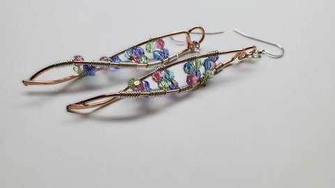 Alexa Martha Designs DNA Strand Double Helix Long Crystal Earrings feature twisted copper wire and colorful faceted beads in purple, green, and blue.